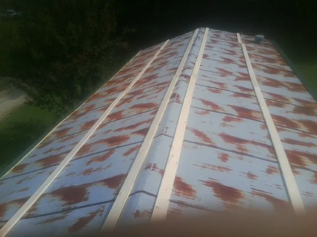 Rusted metal roof panels with new wood purlins before replacement — Storm Damage Roof Repair in Searsboro by Roofing Brothers