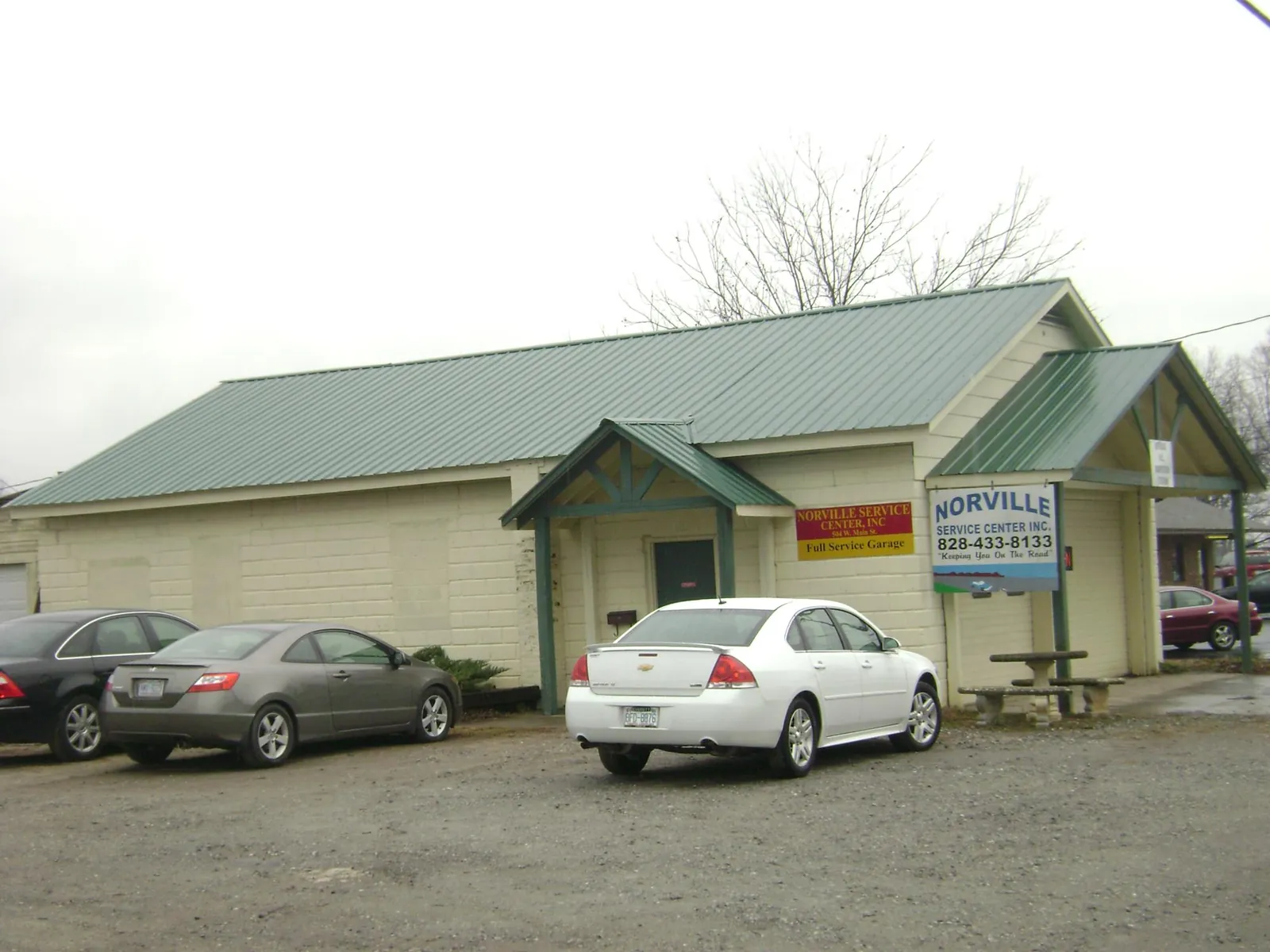 Green metal roof on a service garage with a covered entry in Searsboro